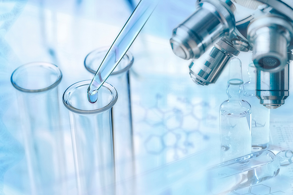 Aus einer Pipette wird eine Flüssigkeit in drei Reagenzgläser getropft. An einer Seite ist ein Mikroskop zu sehen.