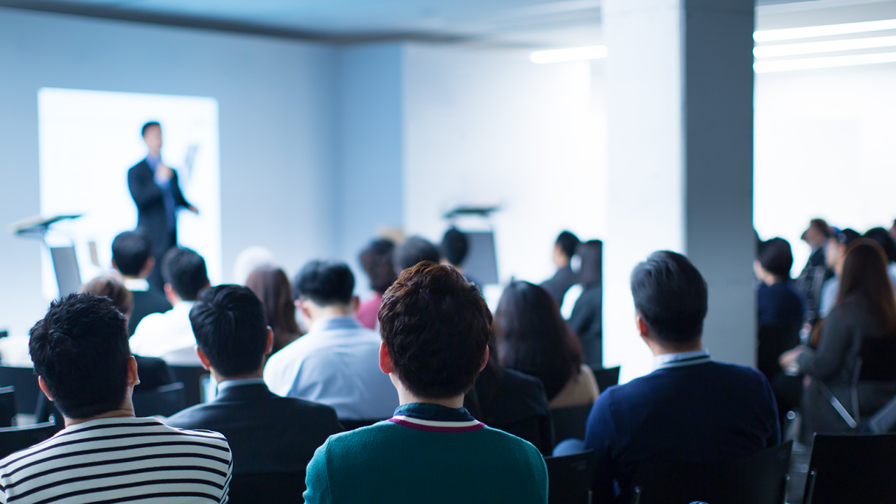 焦点が合っていないインストラクターが、医薬品の追跡とトレースのためのデータ分析手法について聴衆を指導しています。